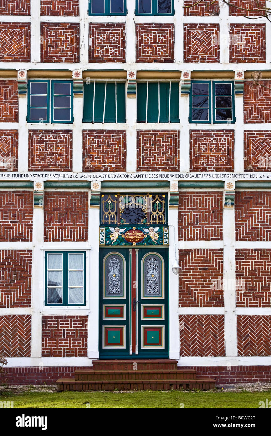 Casa de entramado de madera del histórico, adornado por la puerta de entrada, detalle, antigua masía, Neuenfelde, Altes Land area, el cultivo de frutales, Harb Foto de stock