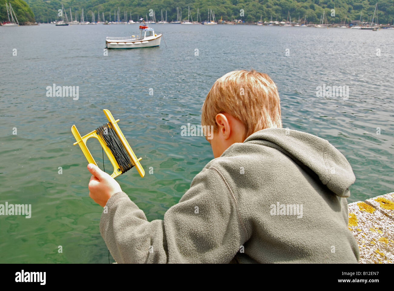 Dinámica práctico Necesario Un chico pesca con línea de mano en Fowey Harbour en Cornwall, Inglaterra,  Reino Unido Fotografía de stock - Alamy