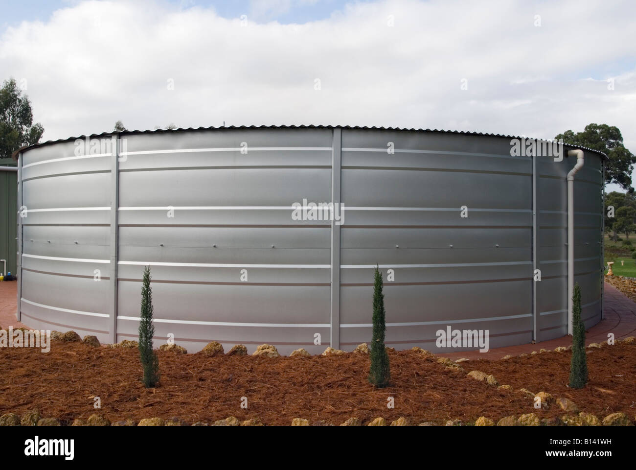 Una circular de 155000 litros de capacidad de acero tanque de almacenamiento de agua de lluvia en una propiedad semi rural en el oeste de Australia. Foto de stock