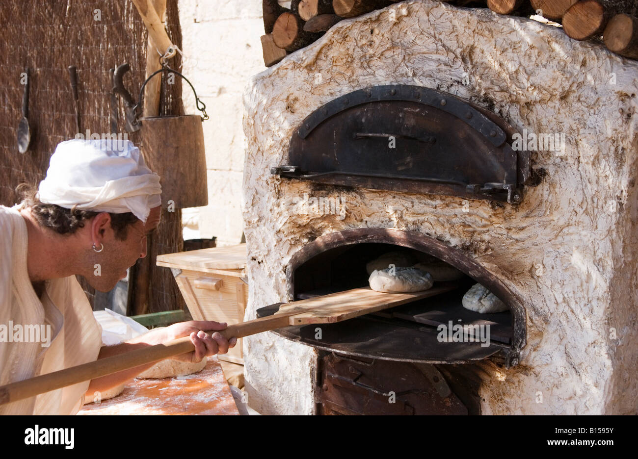 Panadero hornea pan en horno de leña en el mercado artesanal Fotografía de  stock - Alamy
