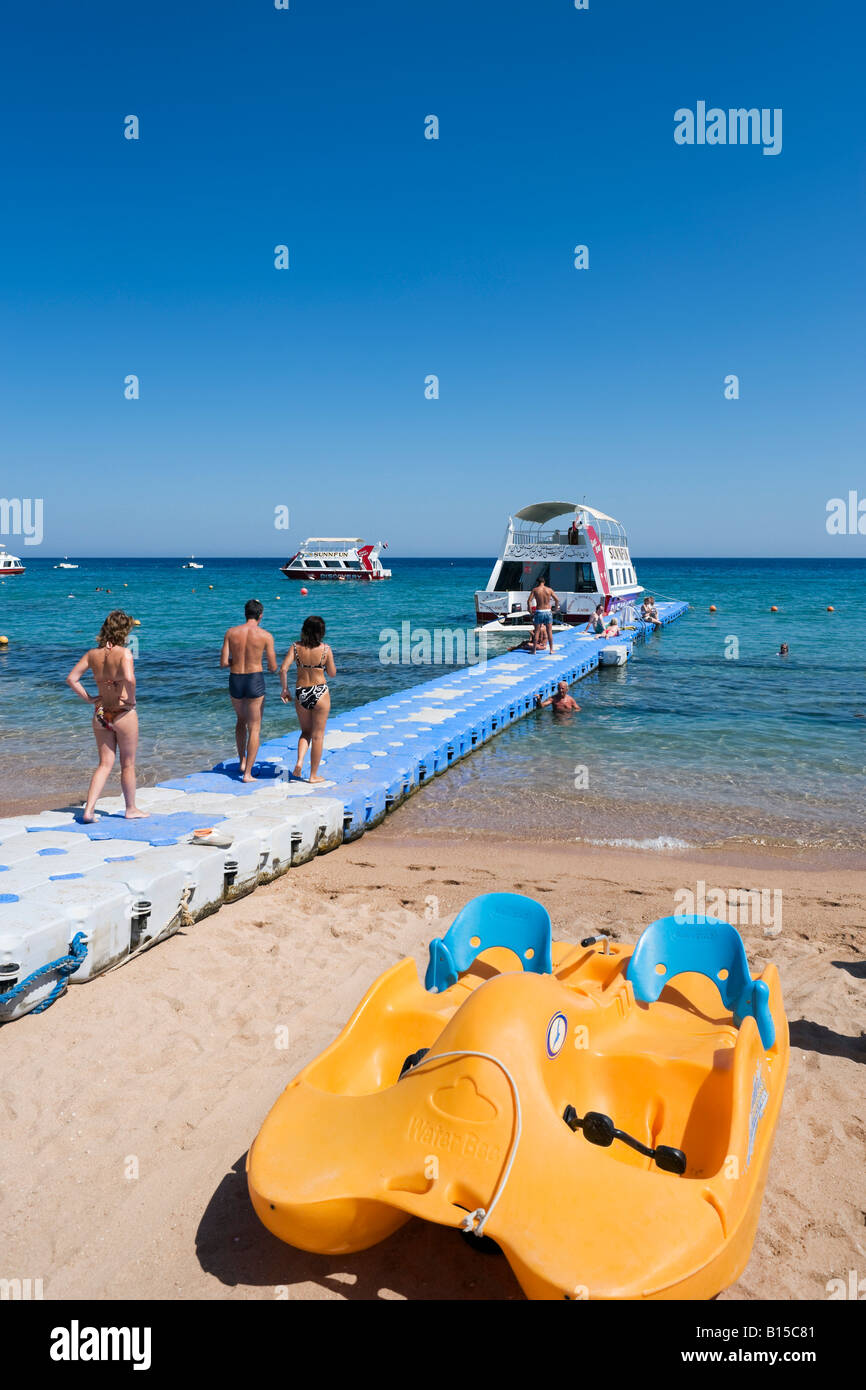Barco con fondo de cristal amarrado a un embarcadero flotante, Naama Bay Beach, Sharm el-Sheikh, en la costa del Mar Rojo, al sur del Sinaí, Egipto Foto de stock
