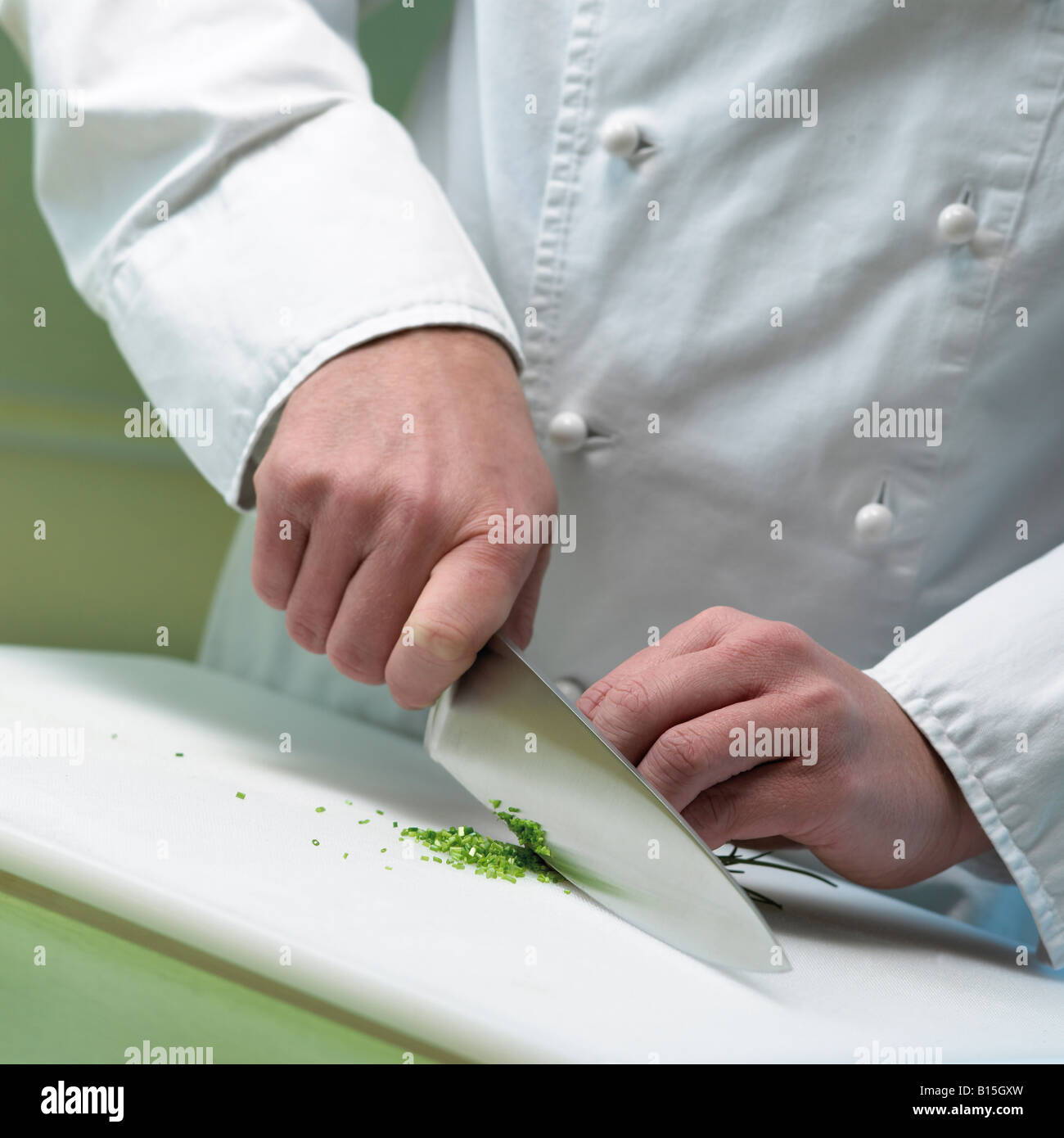 Cook es cortar el perejil de cerca las manos y cuchillo Foto de stock