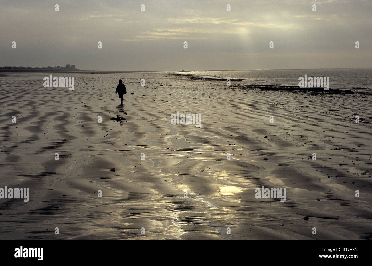 Portbail Normandía kid corriendo en la playa de Sunset Foto de stock