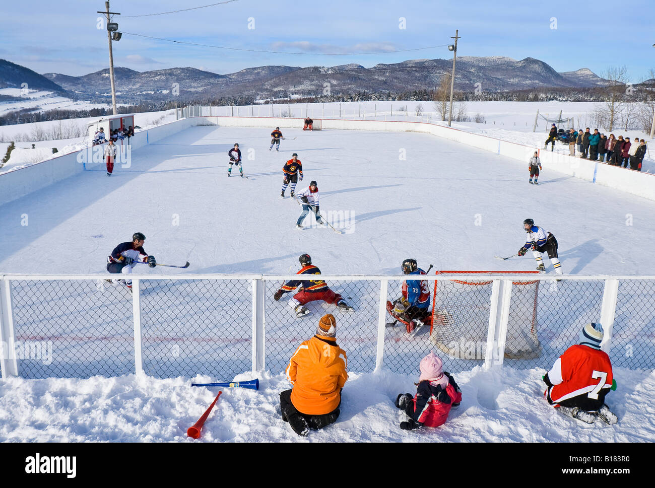 Juego de hockey sobre hielo al aire libre de una aldea en una agradable tarde de sábado, Les Éboulements, Québec, Canadá. Foto de stock