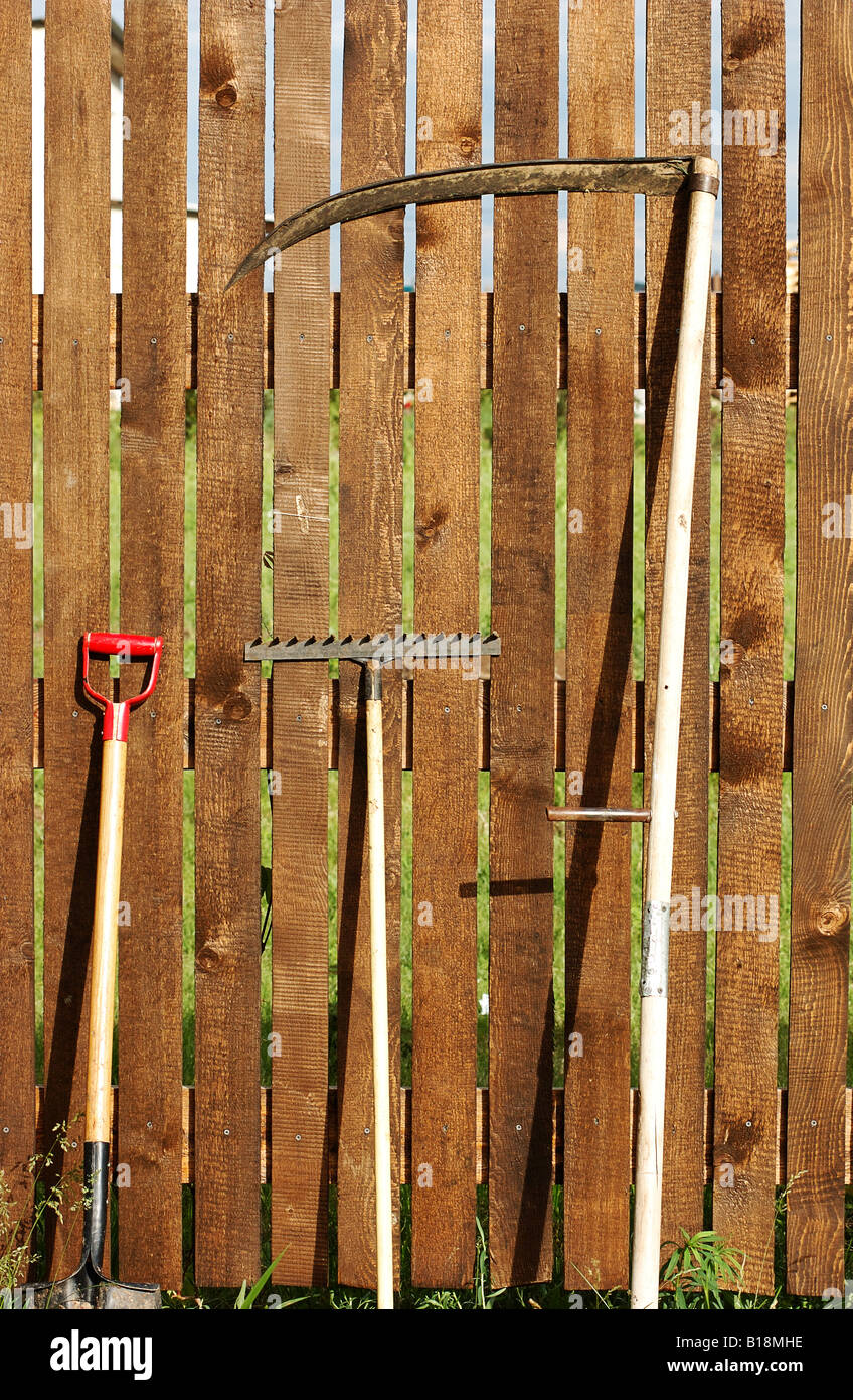 Juego de herramientas de jardín en el patio de madera valla Foto de stock