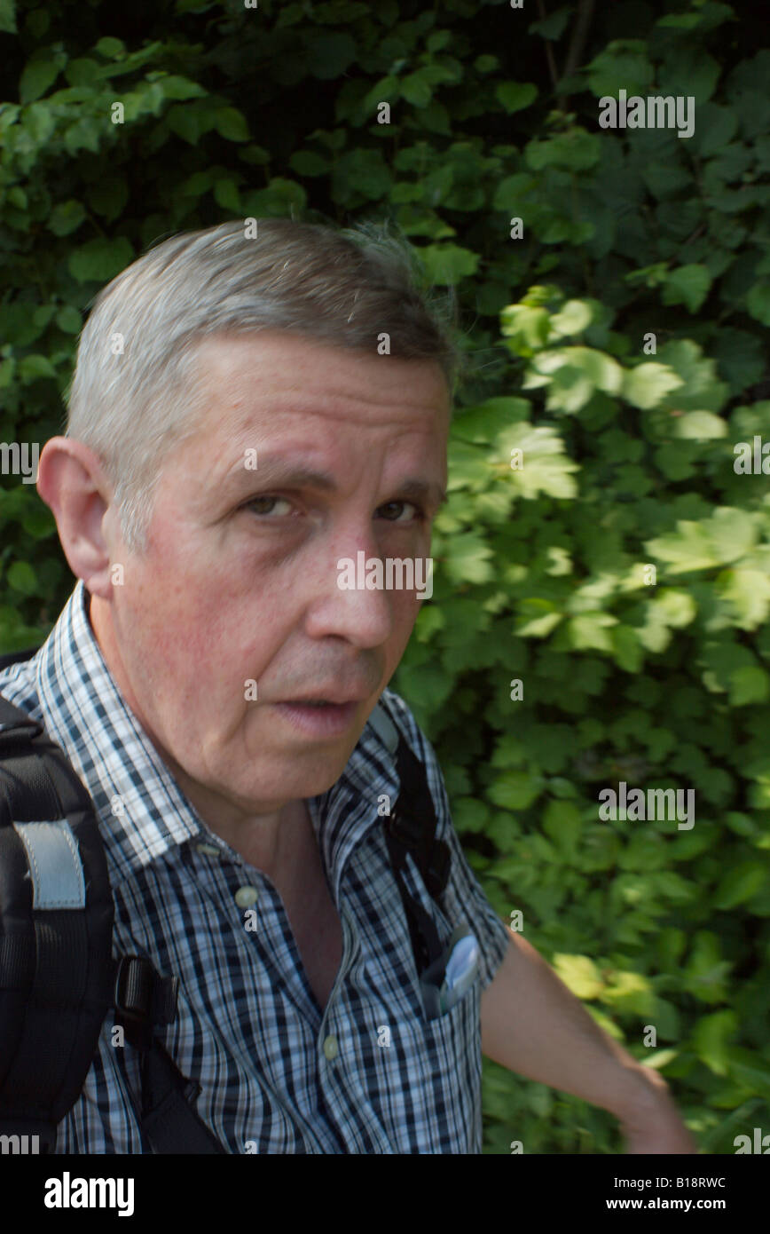 Cerca de la cabeza y los hombros de un hombre de 50 años de caminatas y aspecto cansado autorretrato del fotógrafo Foto de stock