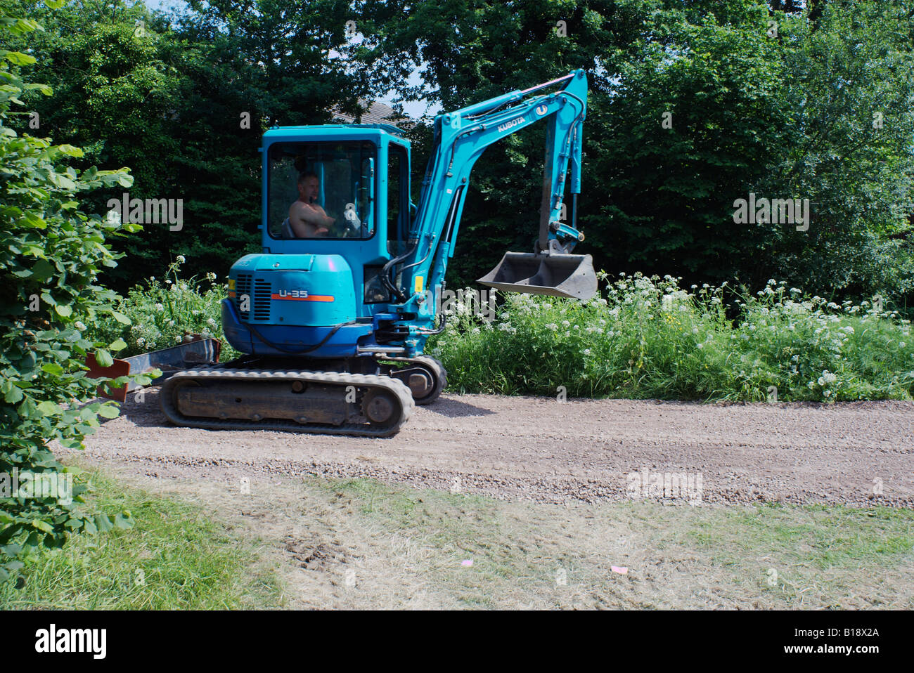 Kubota azul U 35 mini excavadora trabajando en la orilla del canal de Basingstoke en sol brillante en Woking (Surrey, Inglaterra Foto de stock