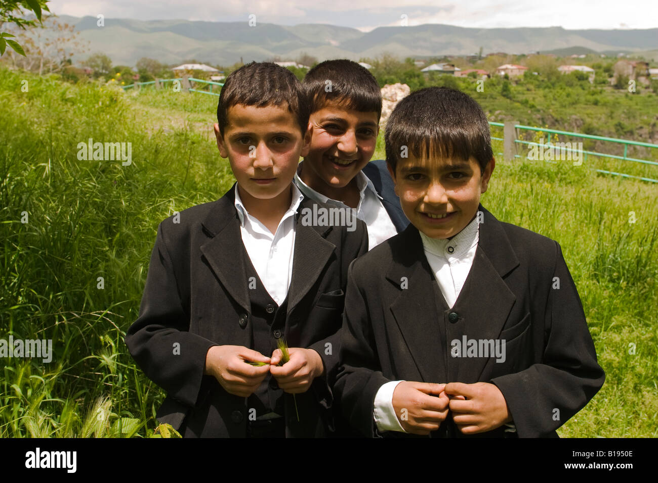 Fuera de Armenia Ereván tres chicos jóvenes en traje oscuro abrigos y  chalecos sonrisa cerca Garni templo Fotografía de stock - Alamy