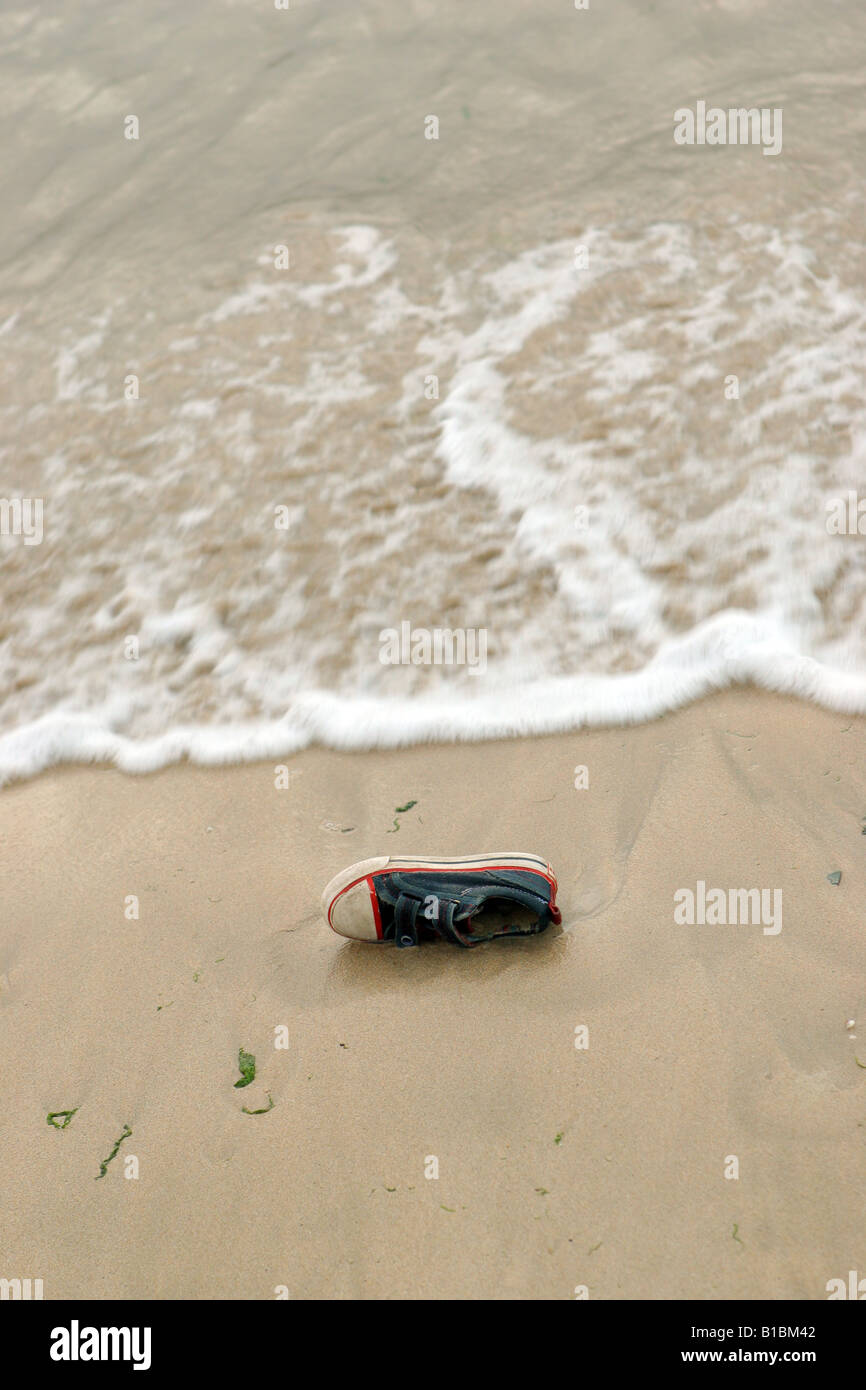 Zapatillas de tela vieja arrastrados hasta la orilla Fotografía de stock -  Alamy