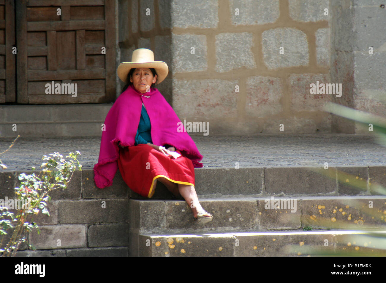 Una mujer andina en Cajamarca, Perú en un tradicional poncho y sombrero se  sienta en los peldaños de la iglesia colonial de Belén Fotografía de stock  - Alamy
