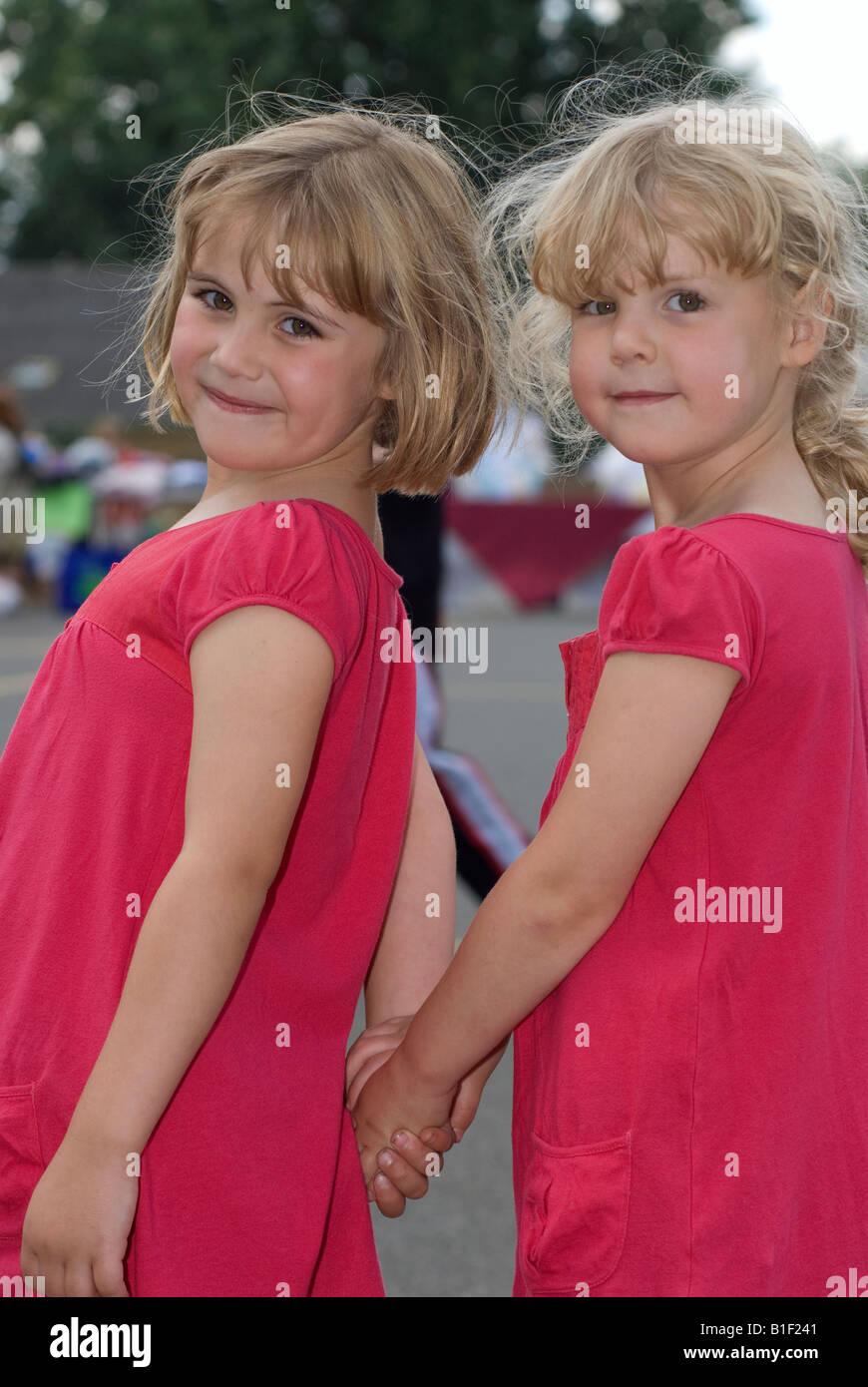 Dos Hermanas jóvenes en el patio de recreo de la escuela feria de verano Isleworth Middlesex UK Foto de stock