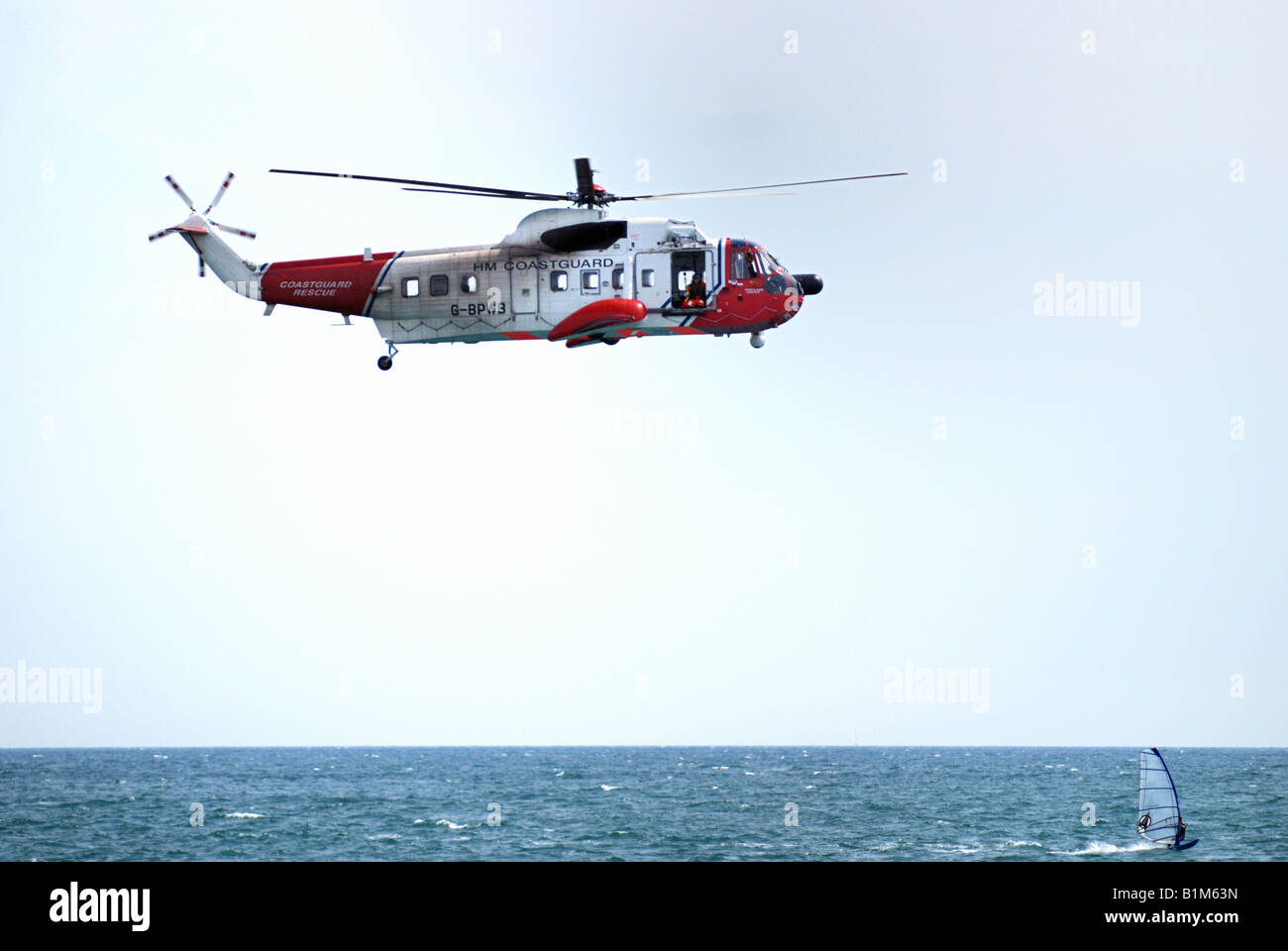 Helicóptero de rescate en el mar de aire a través de la windsurfista Foto de stock