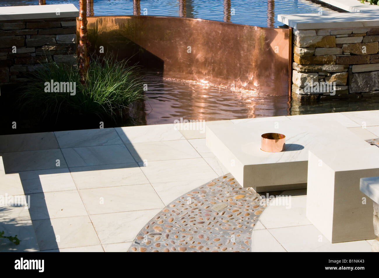 Característica del agua de cobre con un patio con jardín Foto de stock
