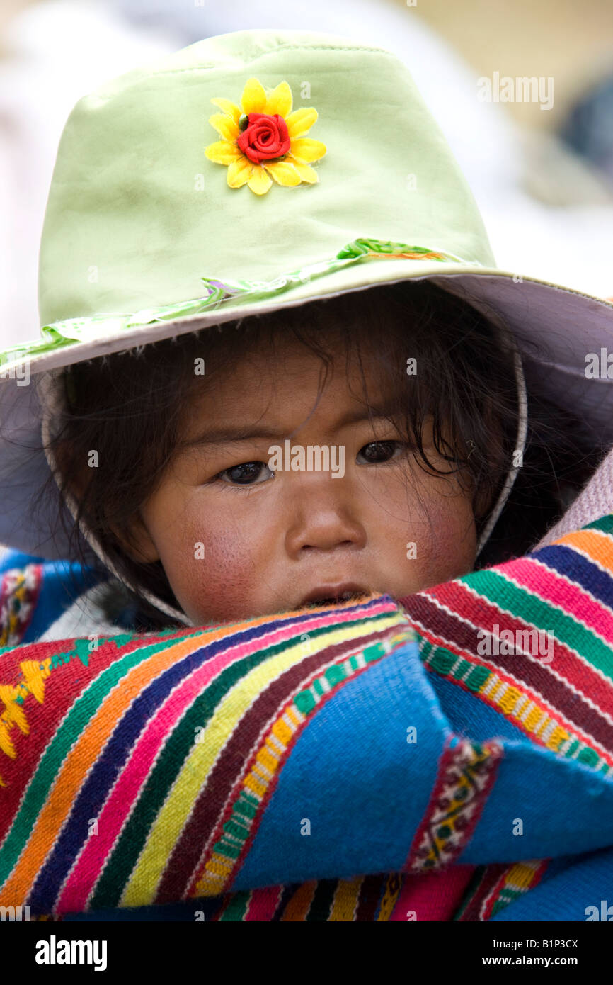 Niño peruano llevada por su madre a la ciudad de Puno, en el sur de Perú, en América del Sur. Foto de stock