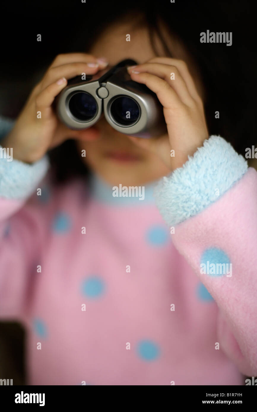 Niño con binoculares muchacha envejecida cuatro años Foto de stock