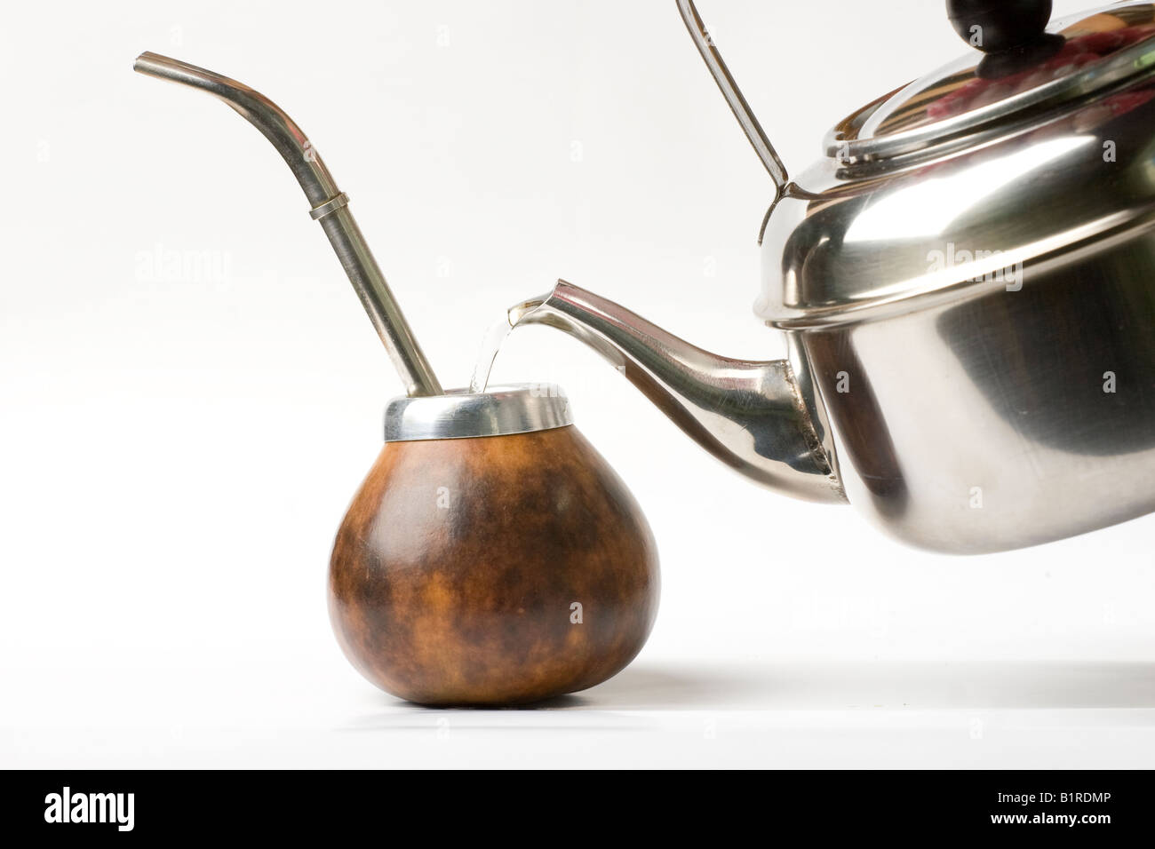 La tetera de metal vertiendo agua caliente dentro de un mate de calabaza  con bombilla de metal aislado de paja sobre fondo blanco Fotografía de  stock - Alamy