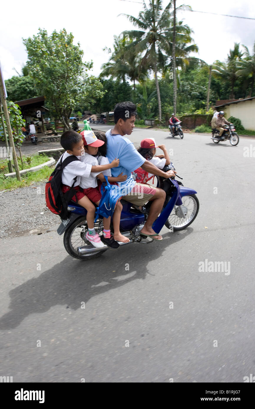 Ciclomotor o motocicleta con 5 pasajeros a bordo, de los cuales 4 son niños, Mataram, la capital de la isla de Lombok, Lesser Sunda Islands, Foto de stock