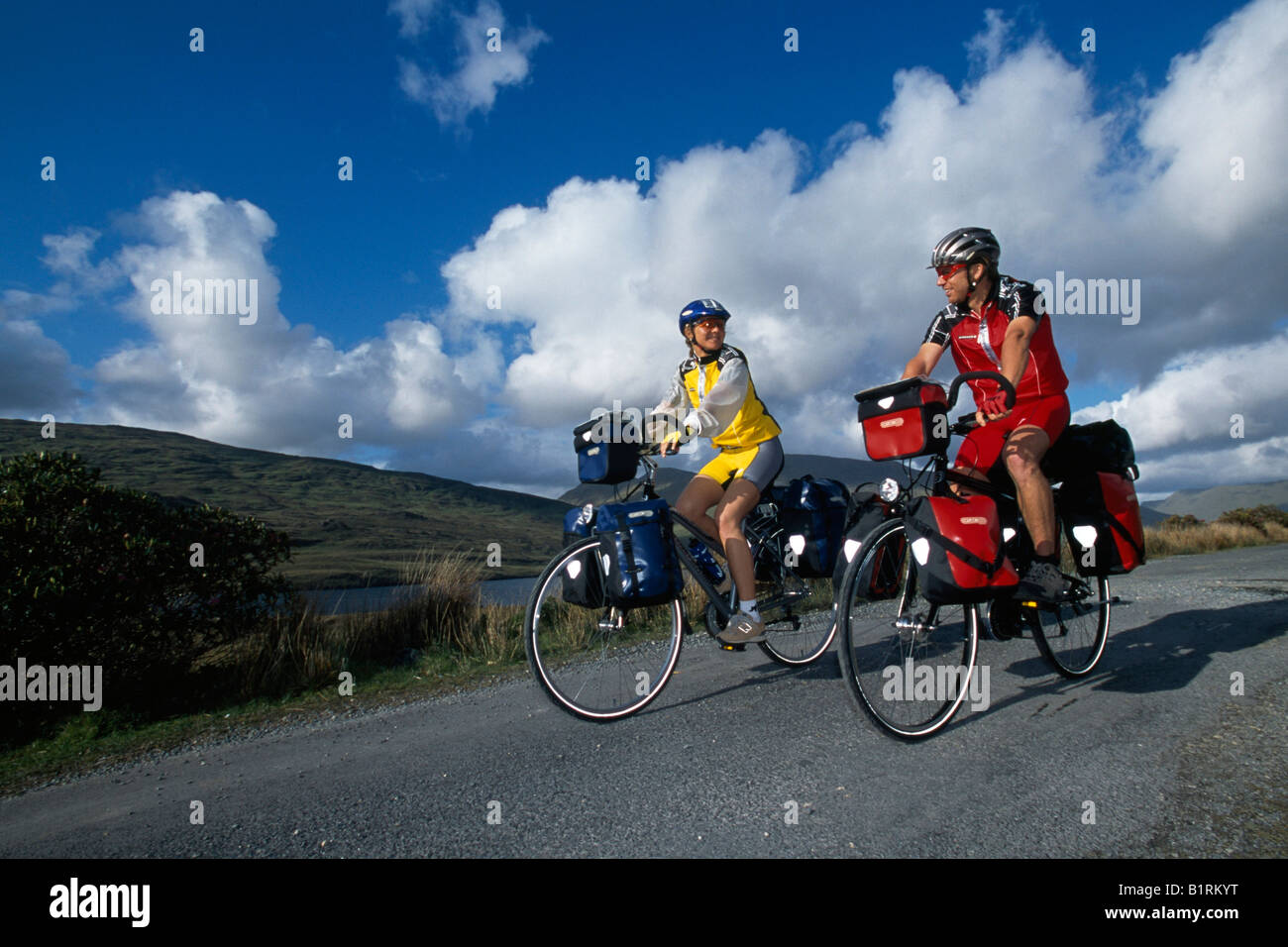 Trekking ciclistas, pareja, Bahía de Killary, Connemara, Irlanda Foto de stock