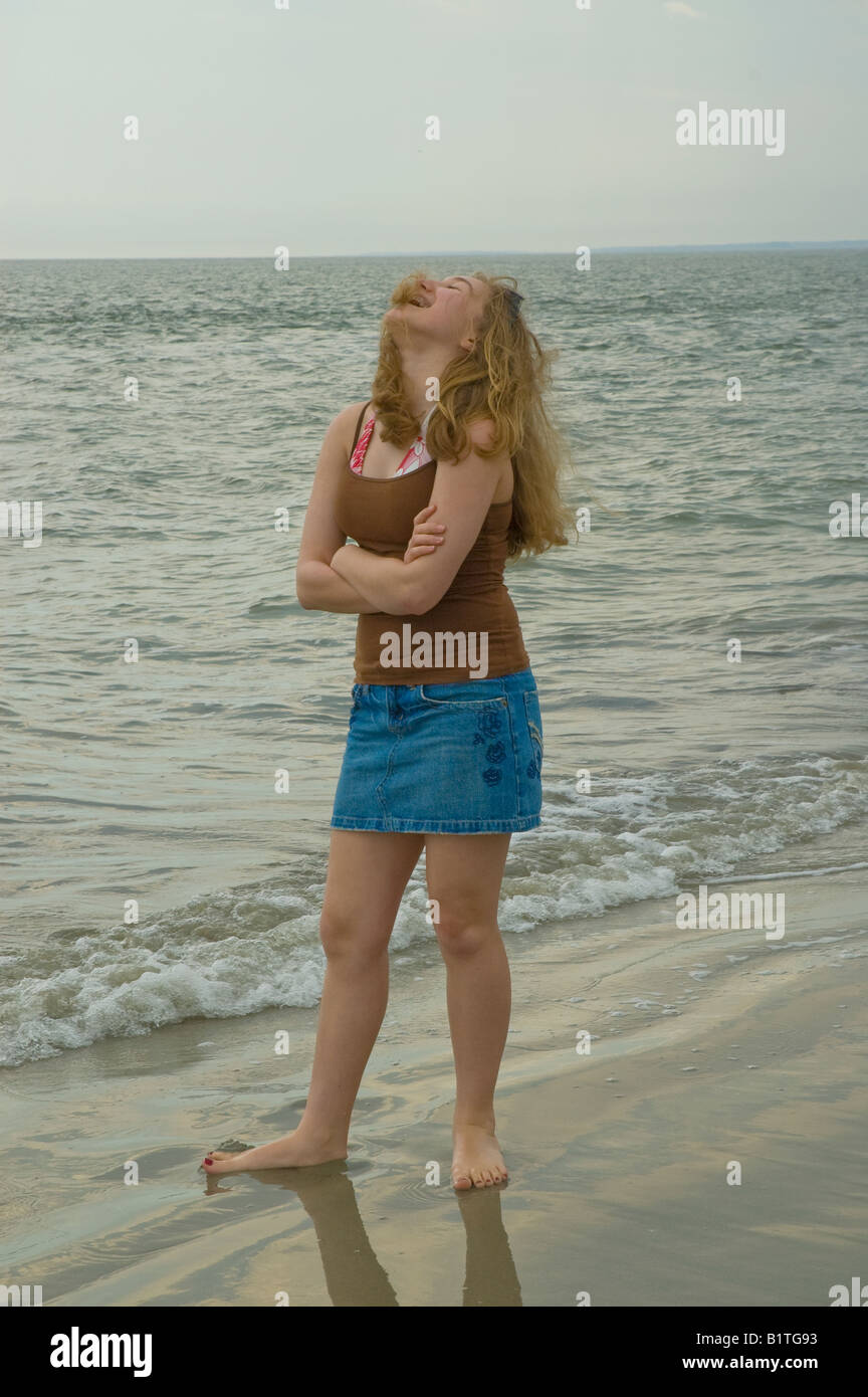 Adolescente de pie en la risa de surf en la playa Seabrook Island South Carolina vacaciones viajes Foto de stock