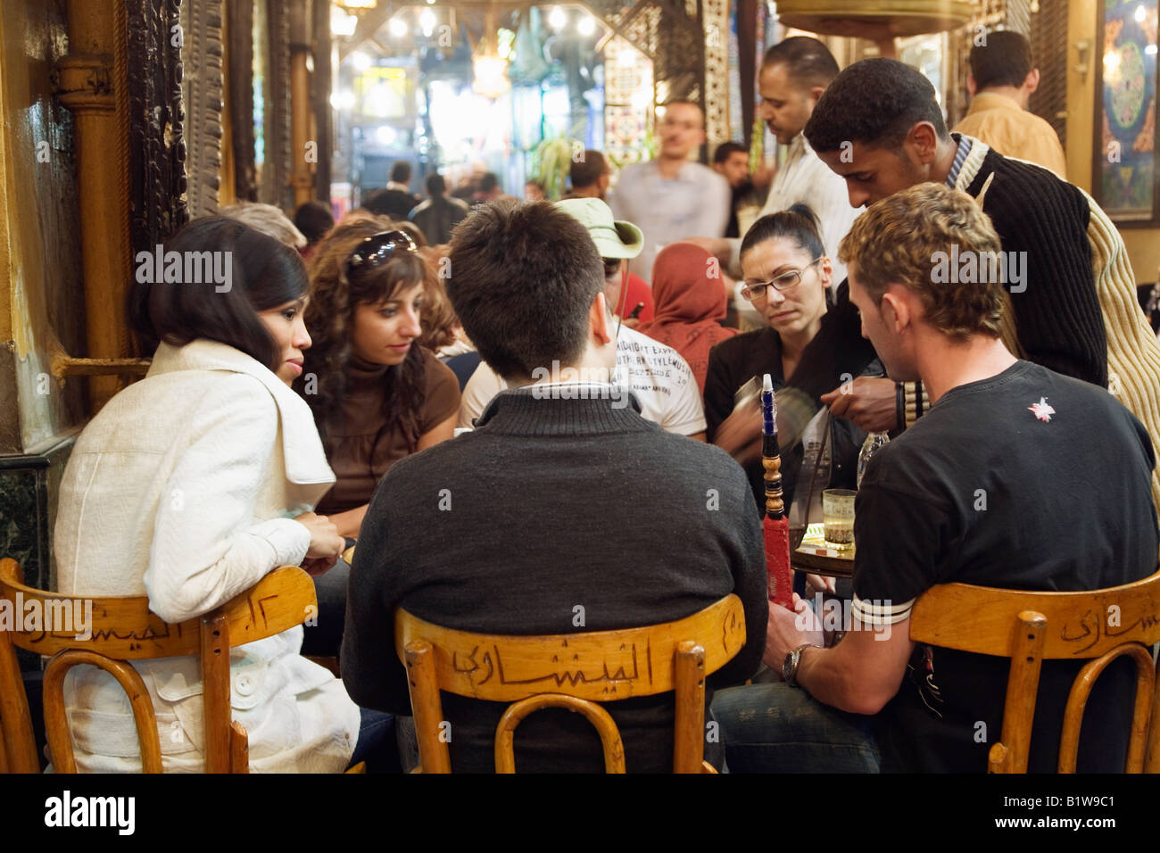 El Cairo, Egipto. Los jóvenes turistas con tubo de agua en Fishawi s coffeehouse, Khan Al Khalili mercado Foto de stock