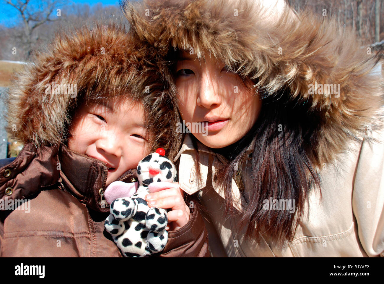 Mujer Asiática y vestida de fur-rayado parkas sonriendo, Retrato Fotografía  de stock - Alamy