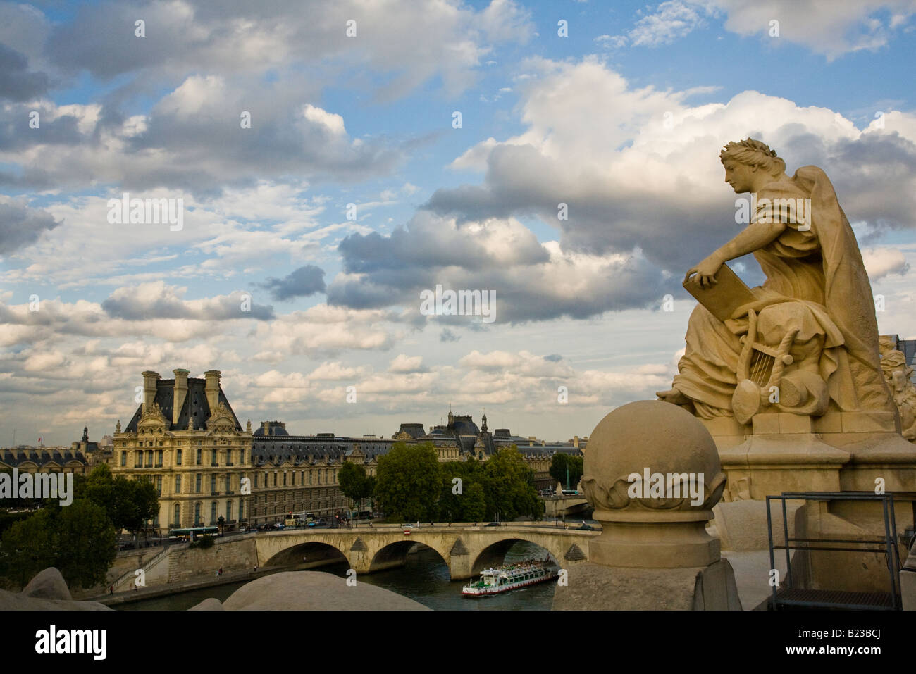 Estatua en el techo del Musee D'Orsay y el fondo del cielo con dramáticas vistas elevadas de paseos en barco por el río Sena por el famoso Museo del Louvre Foto de stock