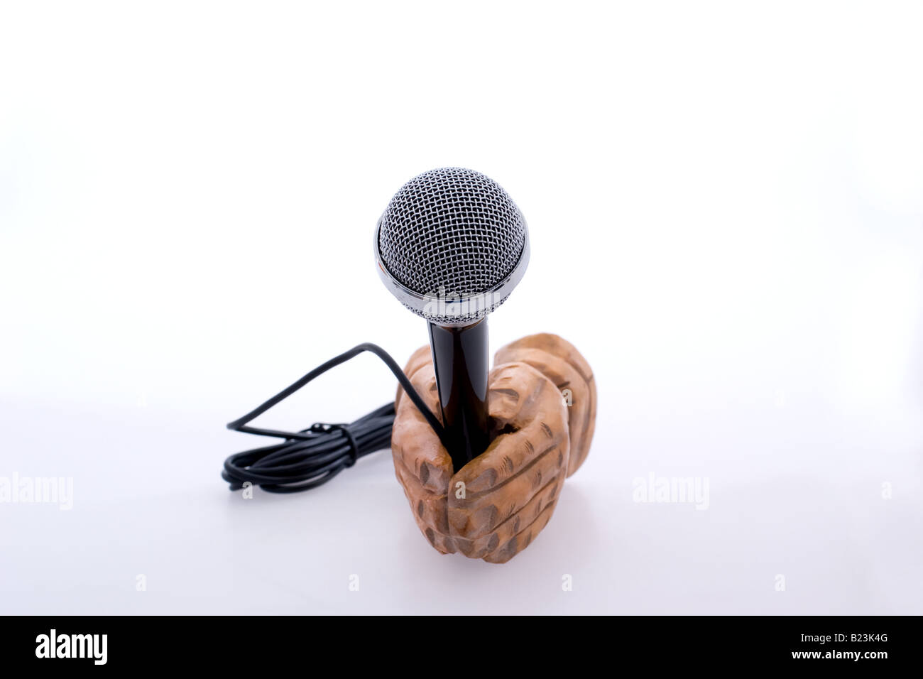Manos de madera sosteniendo un micrófono a la vieja usanza Foto de stock