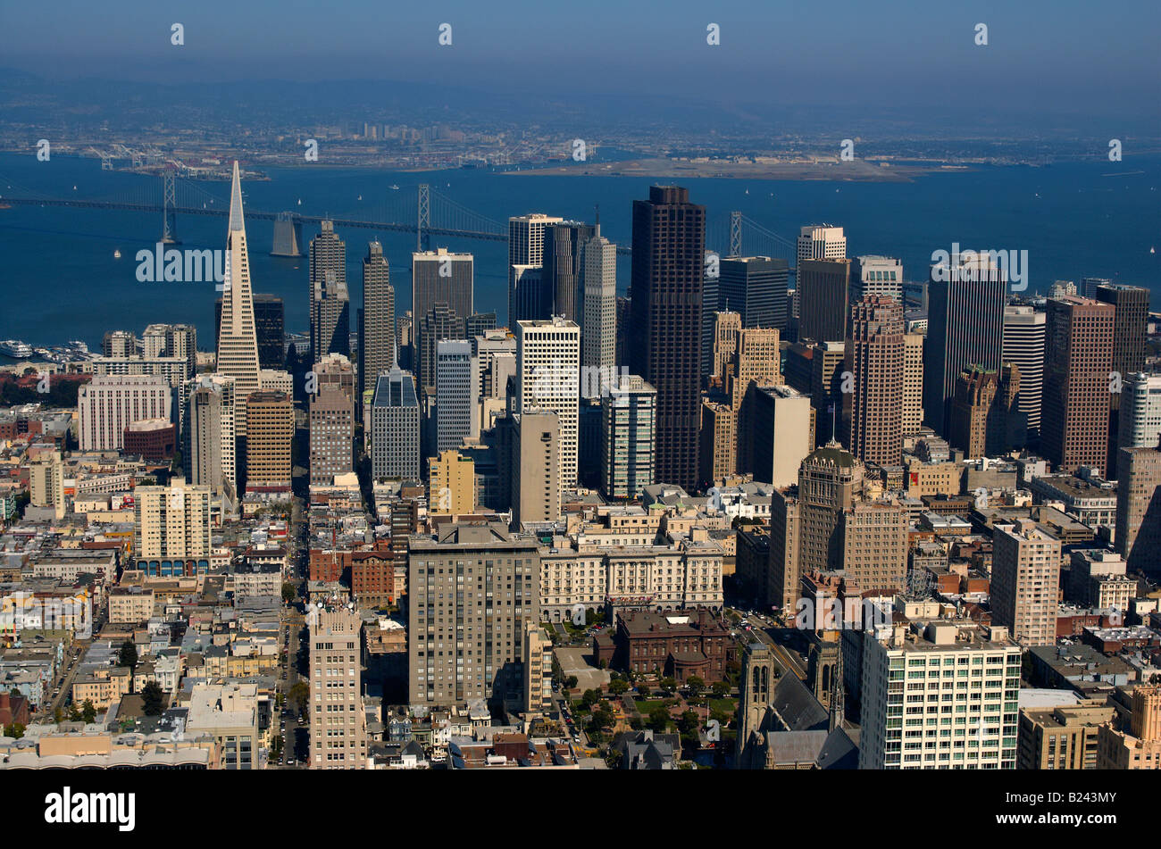 Una vista aérea de la ciudad de San Francisco y el Puente de la Bahía Oakland puerto en el fondo iluminado por el cálido sol de la tarde Foto de stock