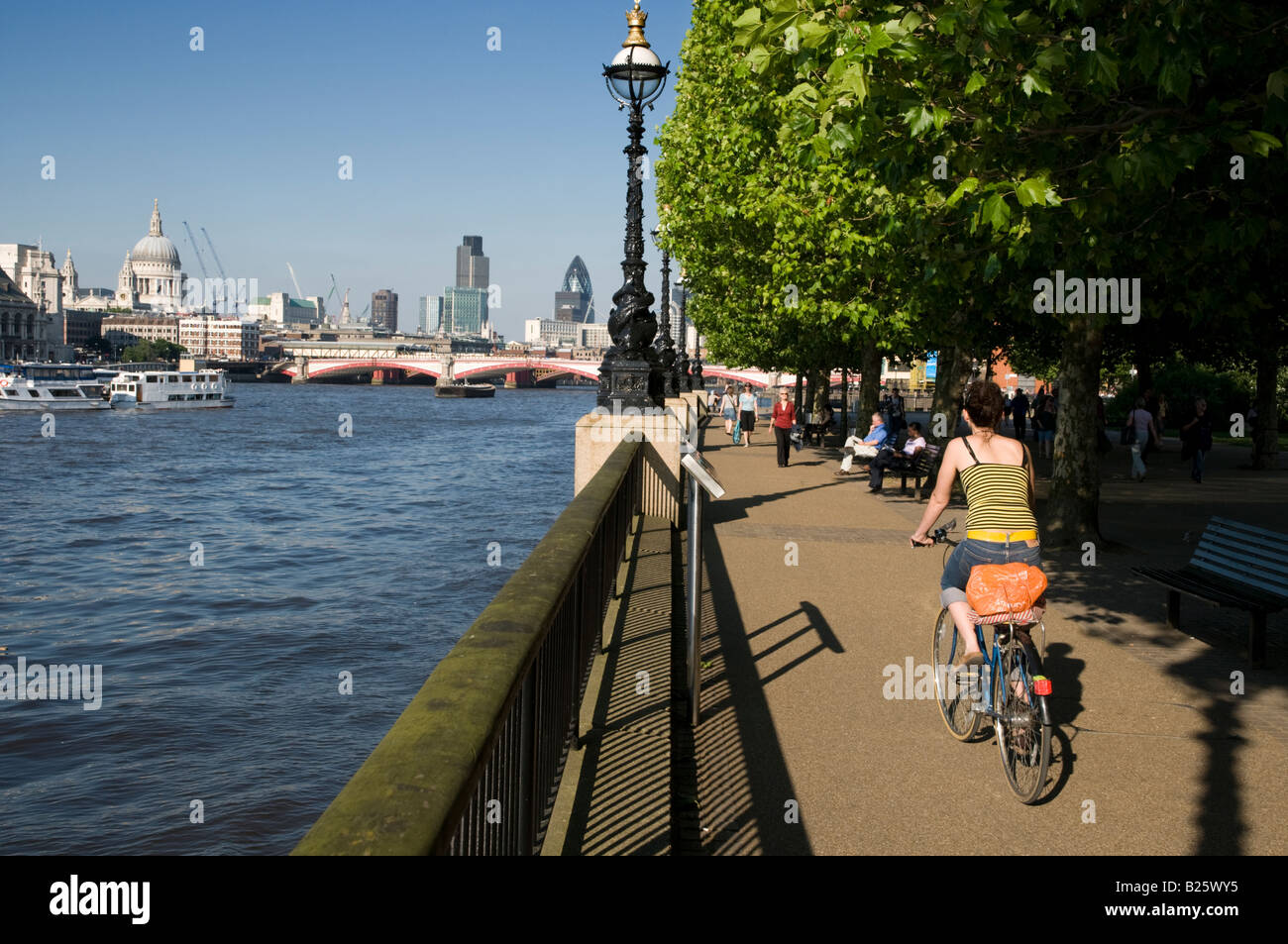Mujer en bicicleta junto al río Támesis, Londres, Inglaterra Foto de stock