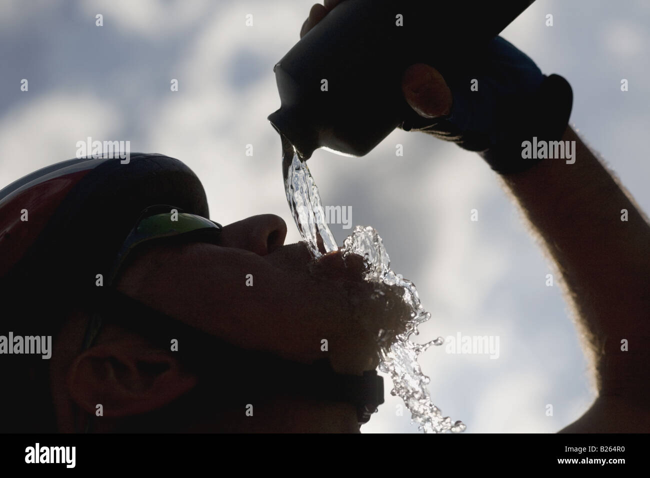 Silueta de un ciclista, agua potable, vista lateral Foto de stock