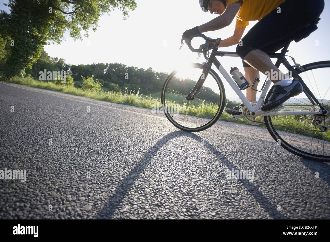 Vista lateral de un hombre ciclismo en carretera Foto de stock