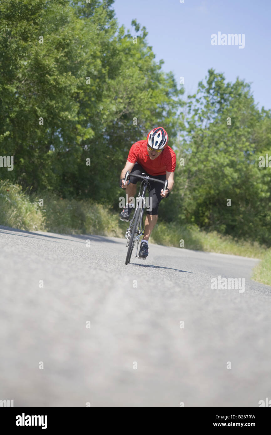 Vista frontal de un hombre ciclismo en carretera Foto de stock