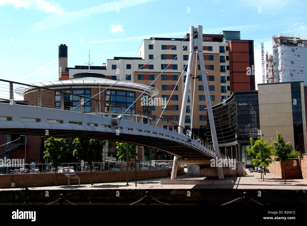 El puente sobre el río Aire en el Brewery Wharf con bloques de apartamentos más allá Foto de stock