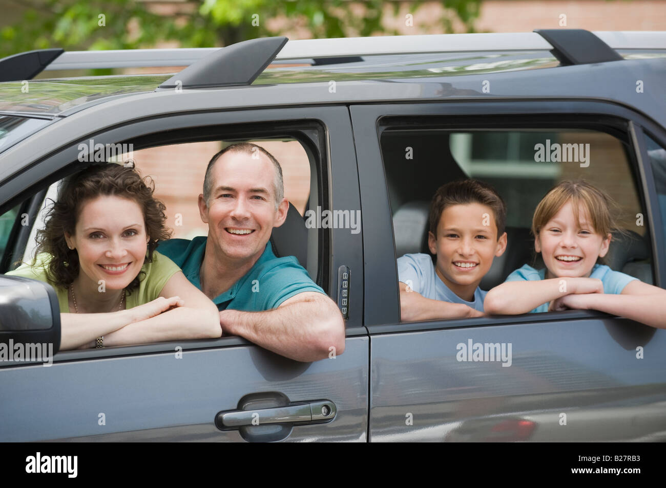 Familia con dos niños mirando las ventanas de autos Foto de stock