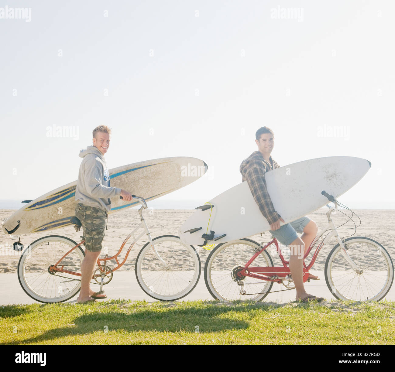 Dos hombres con tablas de surf en bicicletas Fotografía de stock - Alamy