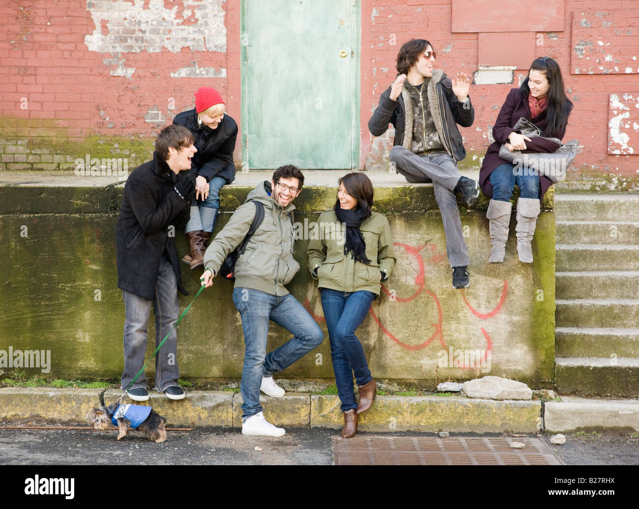 Grupo de amigos sentado en escena urbana Foto de stock