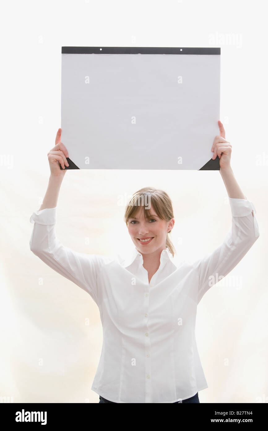 Mujer sosteniendo por encima de la cabeza del papel secante de escritorio Foto de stock