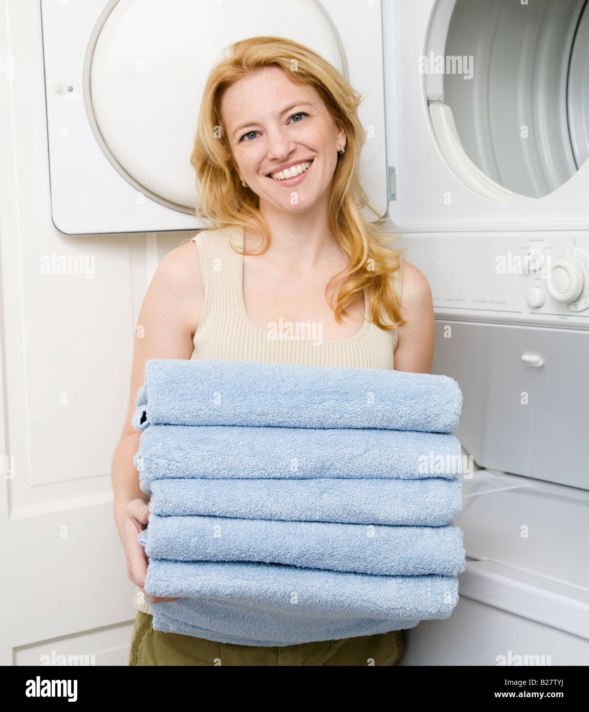 Mujer sosteniendo toallas plegadas Foto de stock