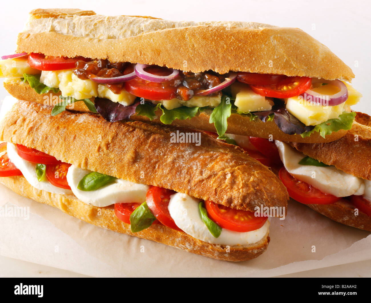 Surtido de sándwiches de baguette contra un fondo blanco, queso y ensalada de tomate y mozzarella, baguette baguette Foto de stock