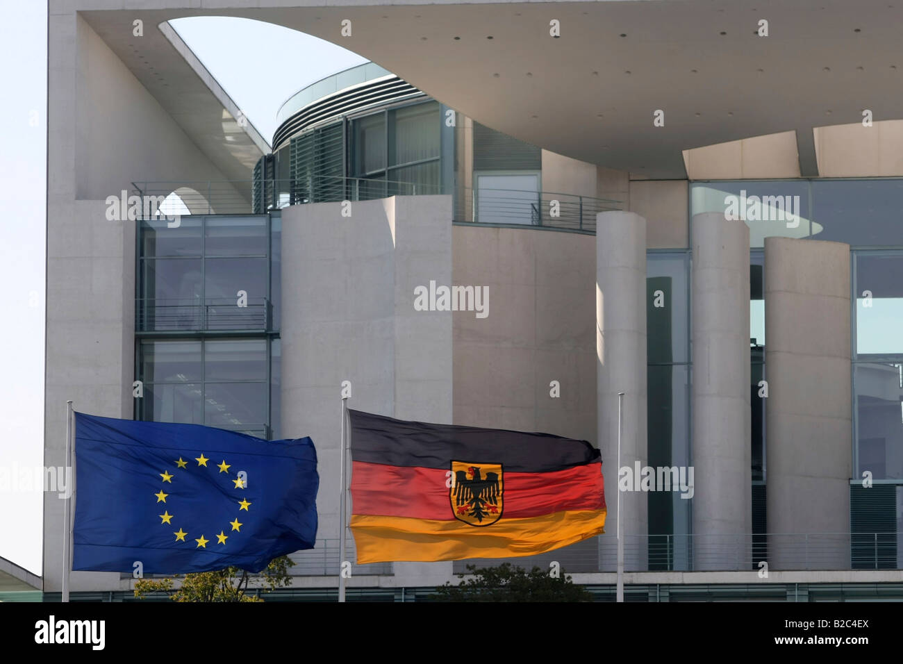 Banderas alemanas y europeas en el viento en frente de la Cancillería Alemana, Bundeskanzleramt Regierungsviertel, Berlín Foto de stock
