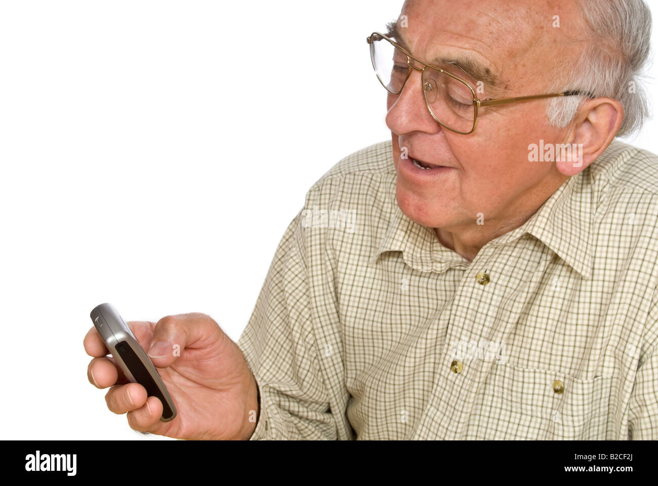 Vertical horizontal de un anciano caballero tiene dificultades para usar los botones pequeños en un teléfono móvil Foto de stock