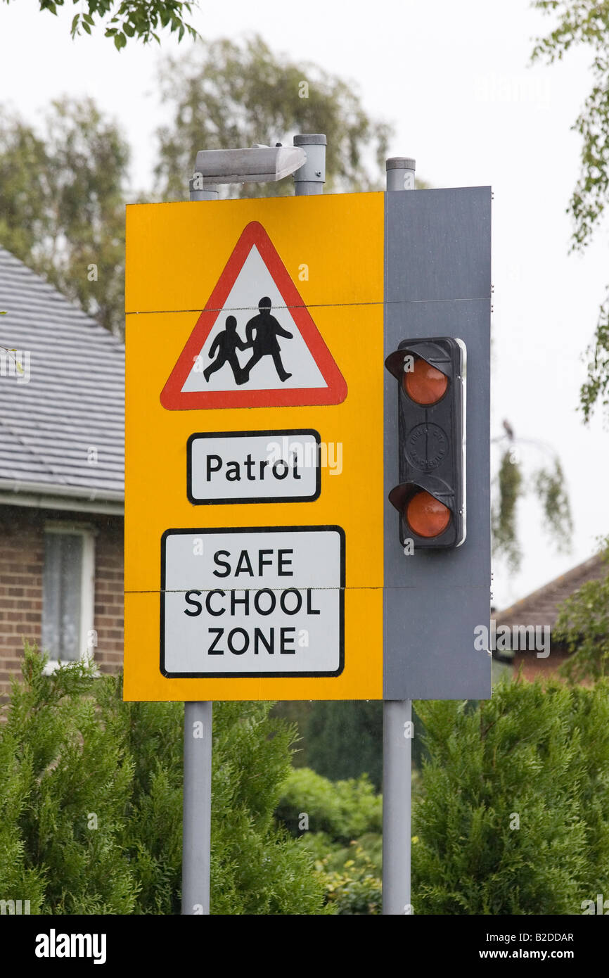 Señal de carretera fuera de escuela inglesa mostrando la escuela cruzar delante de patrulla Foto de stock