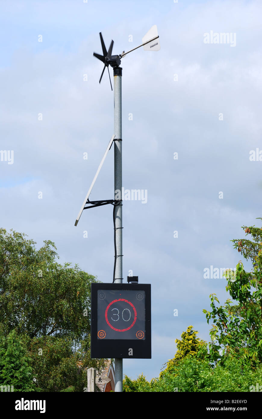 Indicador de velocidad en carretera con turbina de viento y paneles solares, A46 road, Warwickshire, Inglaterra, Reino Unido Foto de stock
