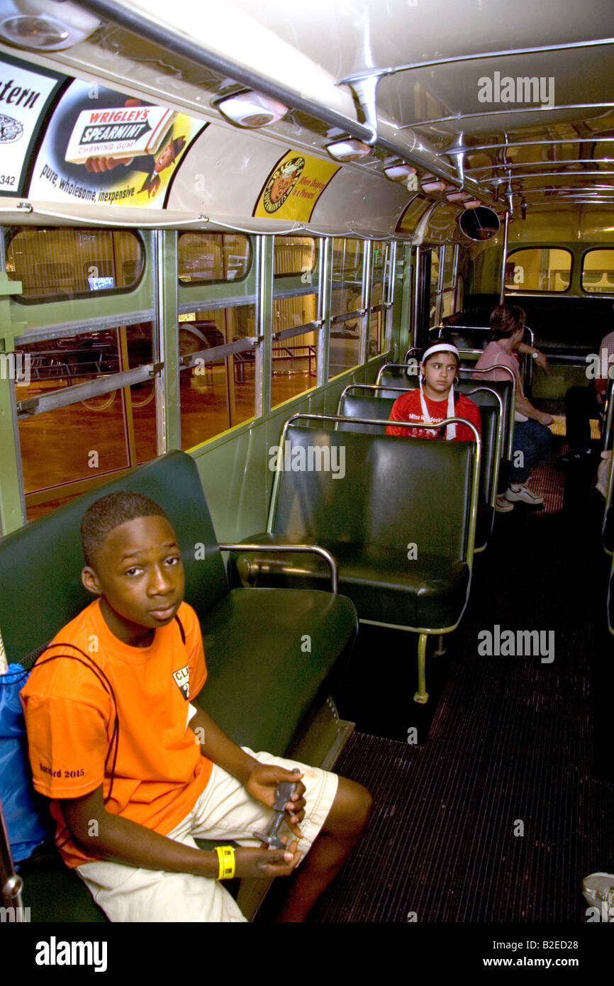 Black boy sentado en Rosa Parks ciudad asiento de autobús en exhibición en el Museo Henry Ford en Dearborn, Michigan Foto de stock