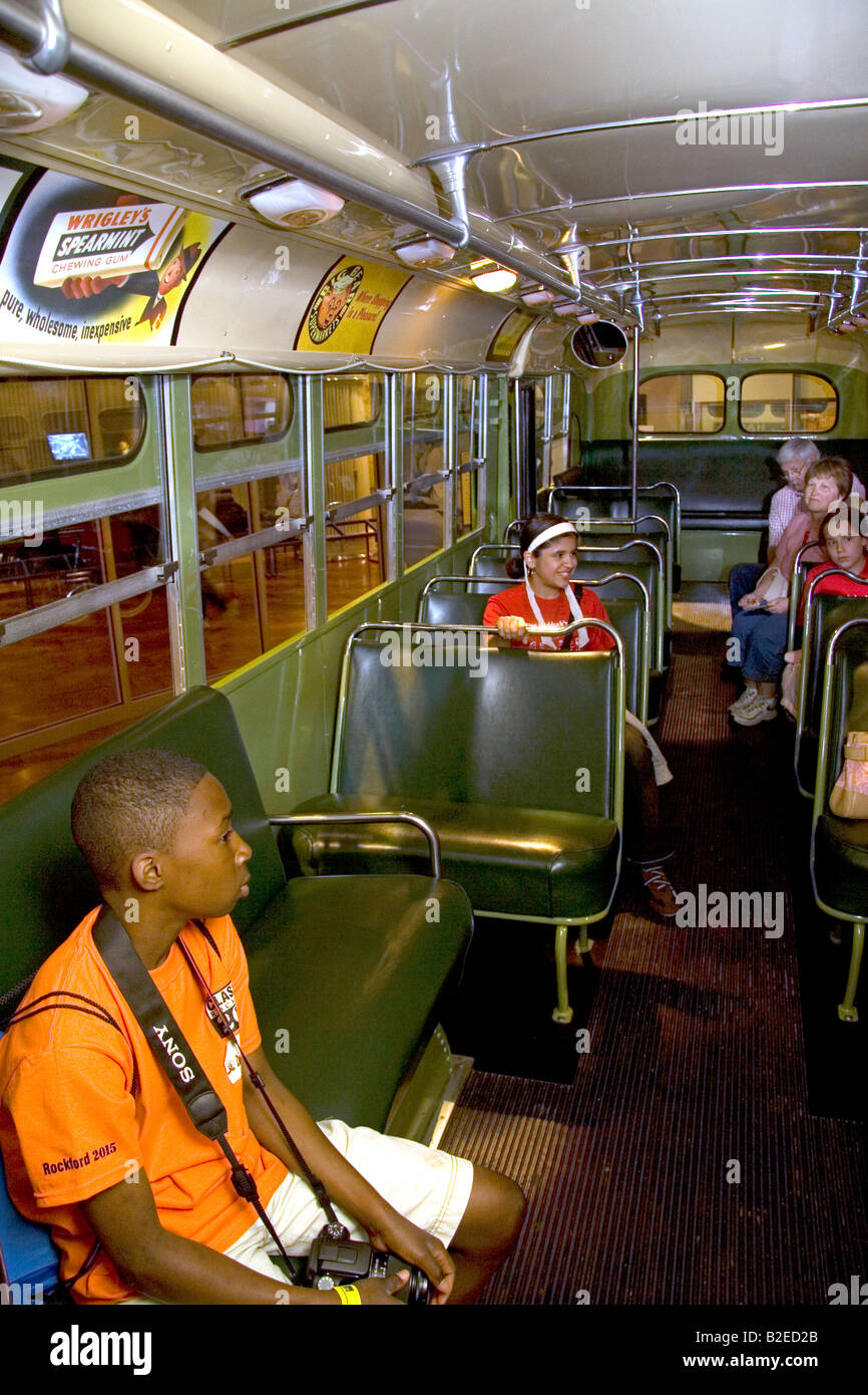 Black boy se sienta en el asiento de autobús de la ciudad de Rosa Parks en exhibición en el Museo Henry Ford en Dearborn, Michigan Foto de stock