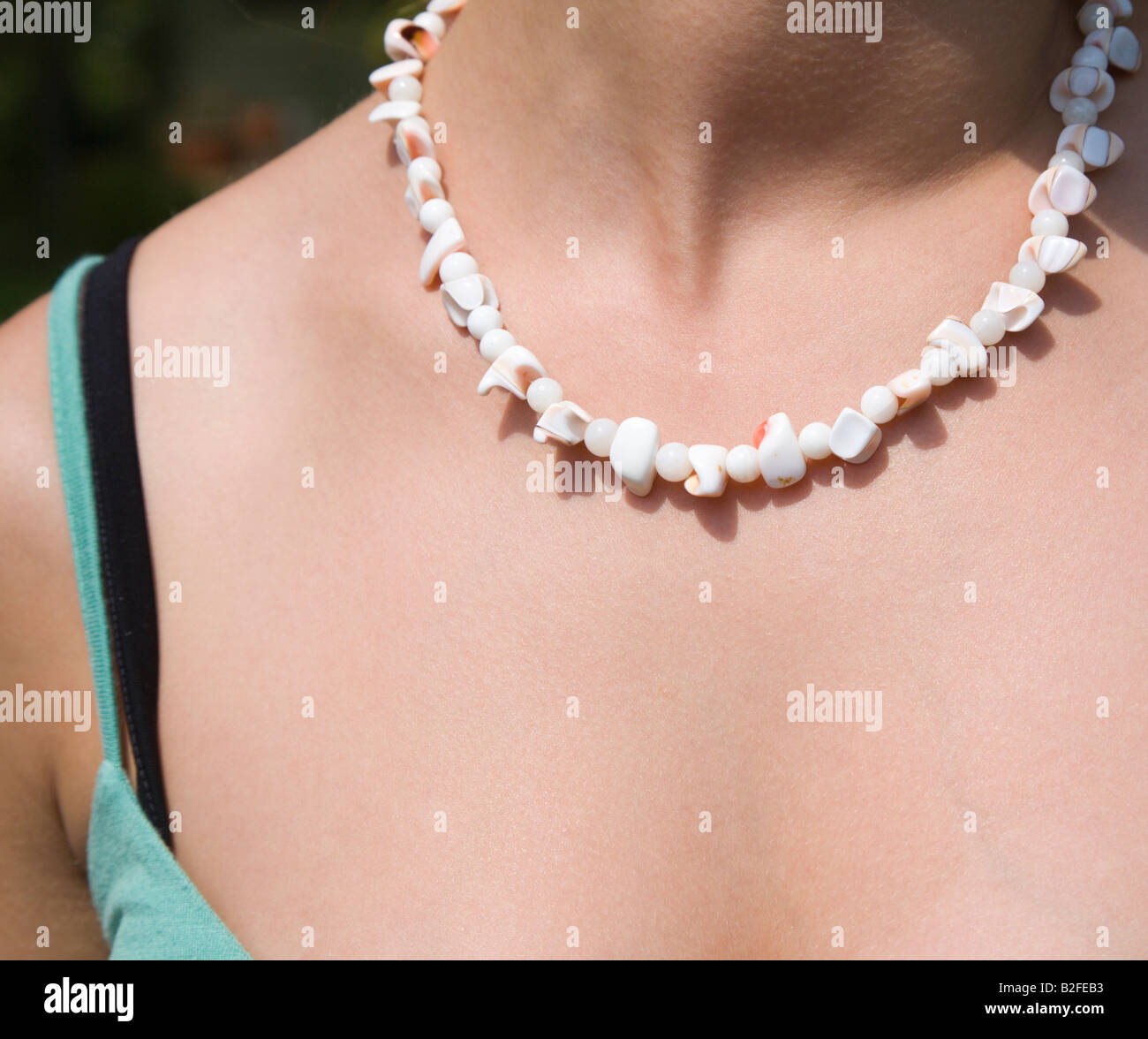 Mujer joven vistiendo un collar blanco. Foto de stock