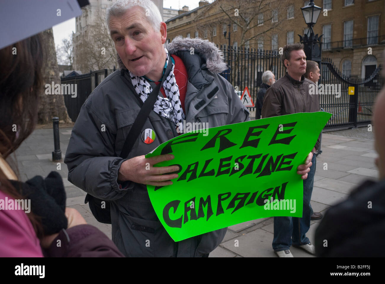 Hombre con bufanda palestina y verde cartel para la campaña Palestina Libre  en Downing St demo ilegal contra el asedio israelí de Gaza Fotografía de  stock - Alamy