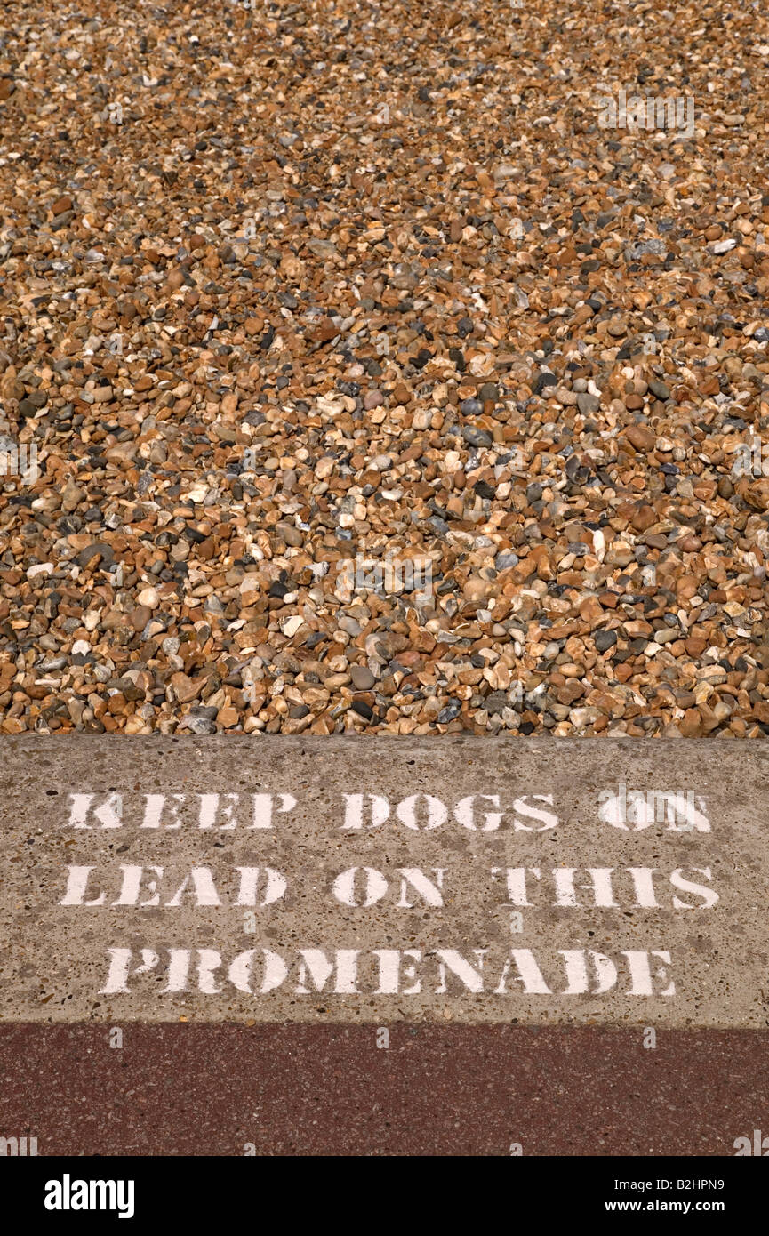 Mantener los perros de plomo firmar estampadas en una acera, además de una playa Foto de stock