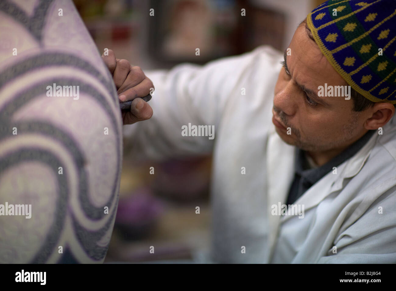 Un trabajador de cerámica pintura jarrones, en Fes, Marruecos Foto de stock