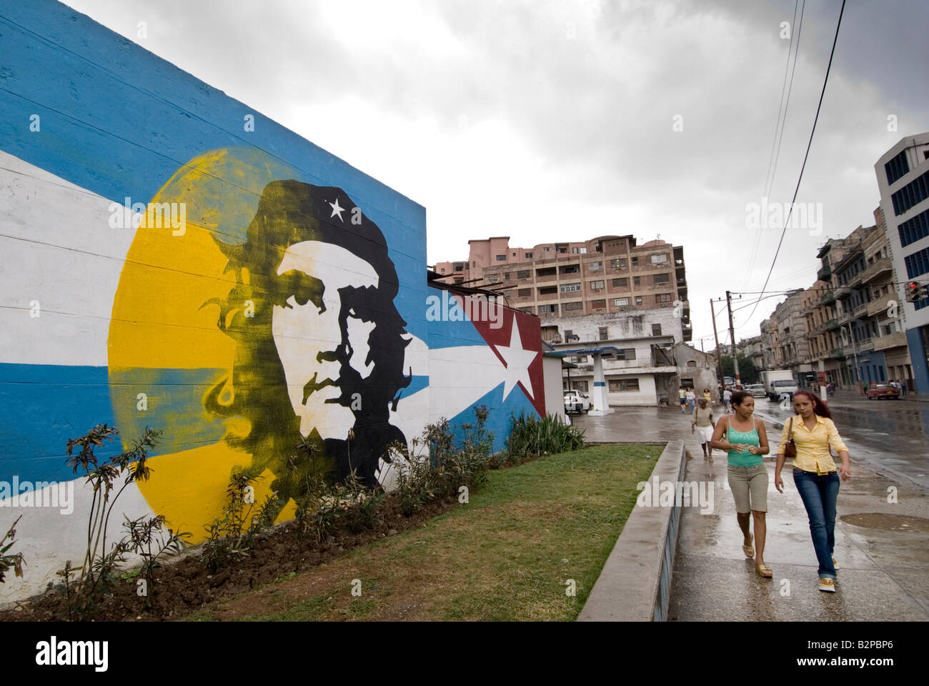 Las mujeres cubanas, pasando por Ernesto Che Guevara mural. Centro. La Habana. Cuba Foto de stock